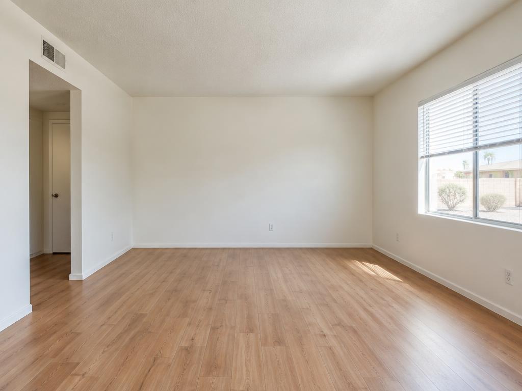 Illustrative empty apartment with bare wood floors and a bright window